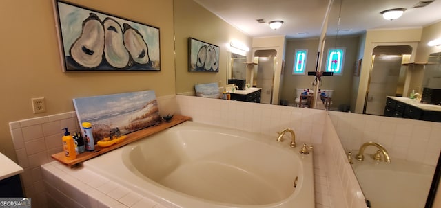 bathroom featuring tiled bath, ornamental molding, and vanity