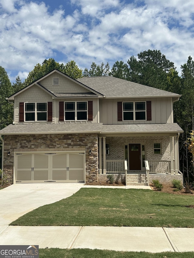 craftsman inspired home with a front yard, a porch, and a garage