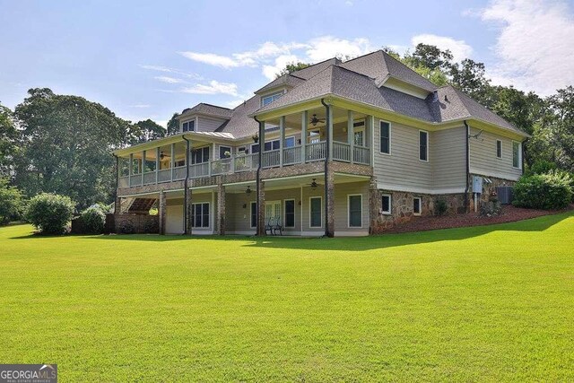 back of house with central air condition unit, ceiling fan, and a lawn