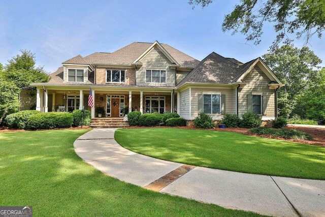 craftsman house with covered porch and a front yard