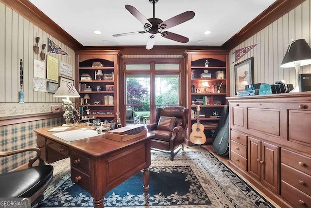 office space with crown molding, wooden walls, and a ceiling fan