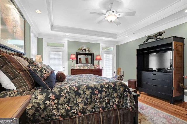 bedroom featuring crown molding, a raised ceiling, wood finished floors, ceiling fan, and recessed lighting