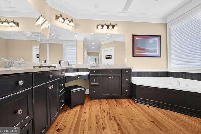 bathroom with a tub to relax in, ceiling fan, wood-type flooring, and ornamental molding