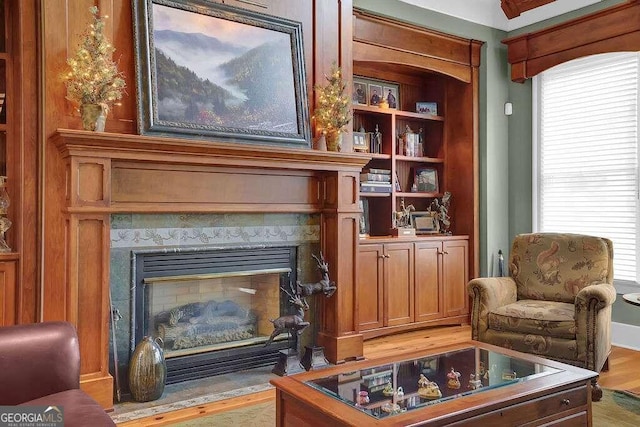 sitting room with a high end fireplace and light wood finished floors