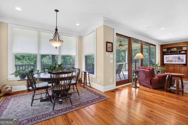 dining area with crown molding and light wood-type flooring