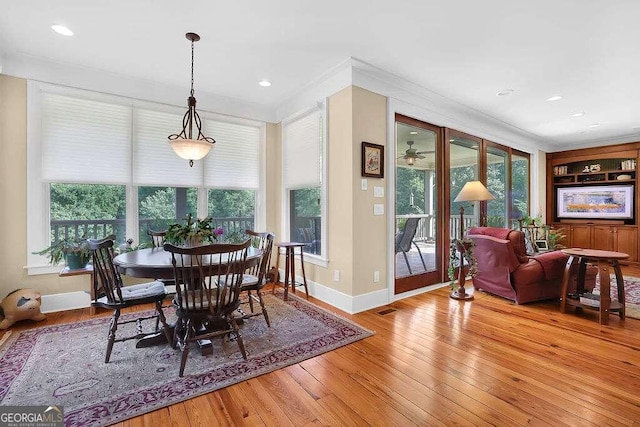 dining space featuring wood-type flooring, crown molding, baseboards, and recessed lighting