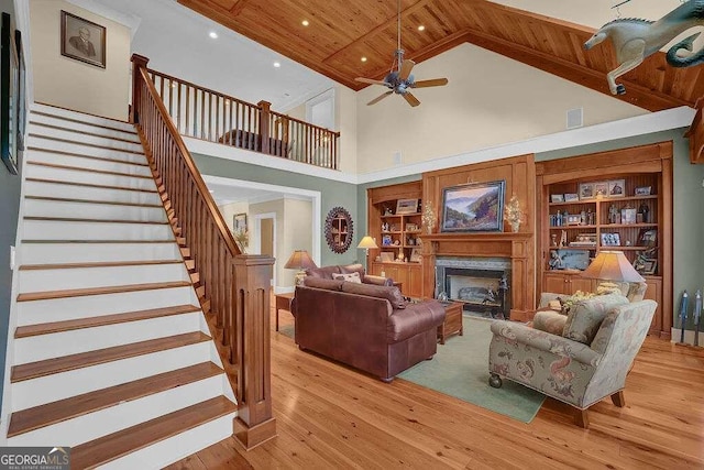 living room with built in features, wood ceiling, high vaulted ceiling, ceiling fan, and light wood-type flooring