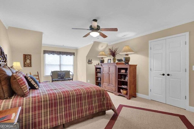 carpeted bedroom featuring a closet, ceiling fan, and ornamental molding