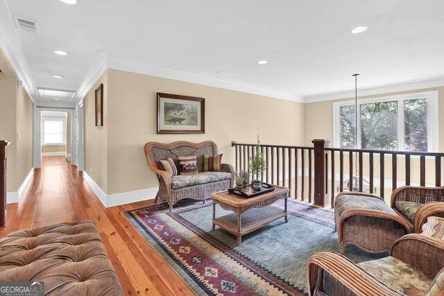 living room featuring light wood-type flooring and crown molding