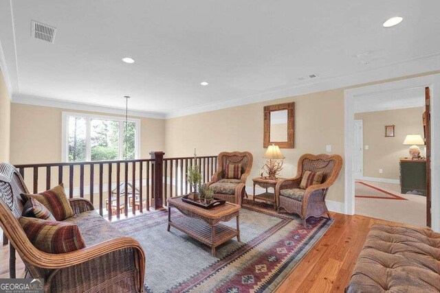 living room featuring light wood-type flooring and crown molding