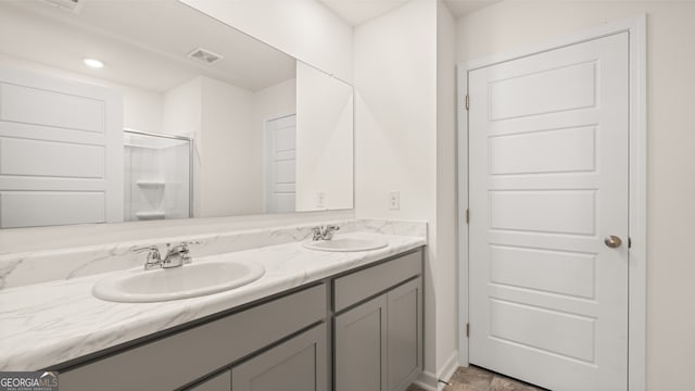 bathroom with vanity and a shower with door