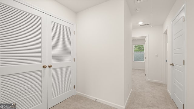 corridor featuring light colored carpet