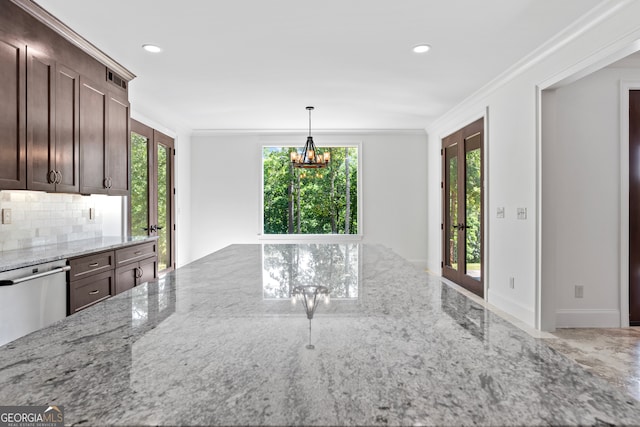 kitchen featuring tasteful backsplash, an inviting chandelier, dark brown cabinetry, and light stone counters