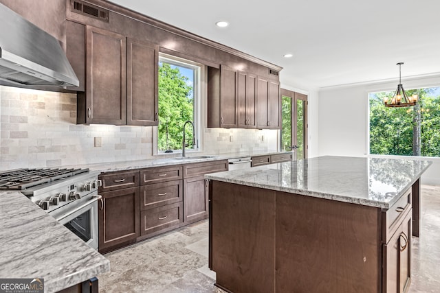 kitchen featuring wall chimney exhaust hood, light stone countertops, high end stove, and sink