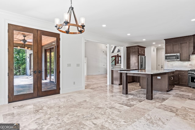 kitchen with french doors, a center island, a breakfast bar, appliances with stainless steel finishes, and backsplash