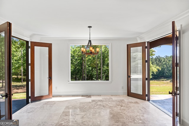 doorway with ornamental molding, french doors, and a chandelier