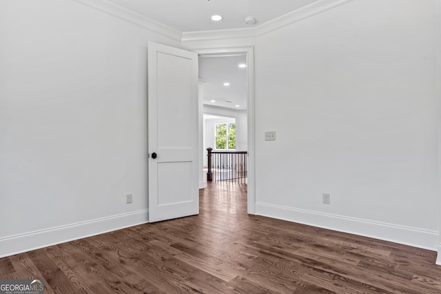 spare room featuring ornamental molding and dark wood-type flooring