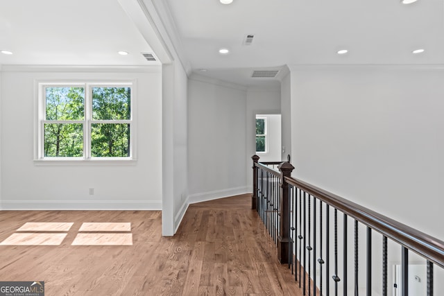 corridor with hardwood / wood-style flooring and crown molding