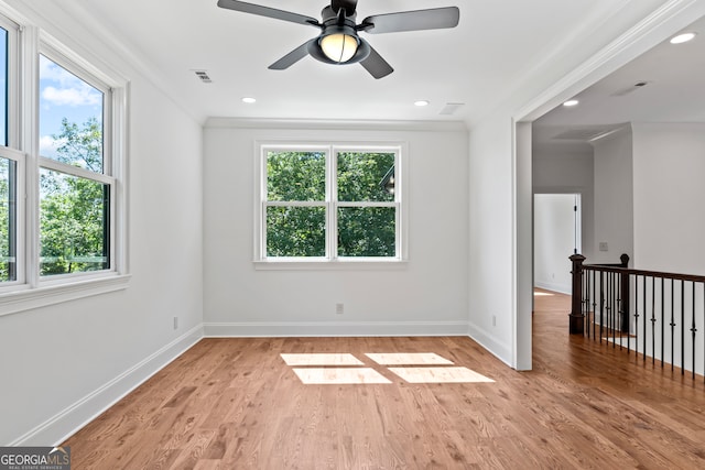 empty room with ornamental molding, light hardwood / wood-style flooring, and a healthy amount of sunlight