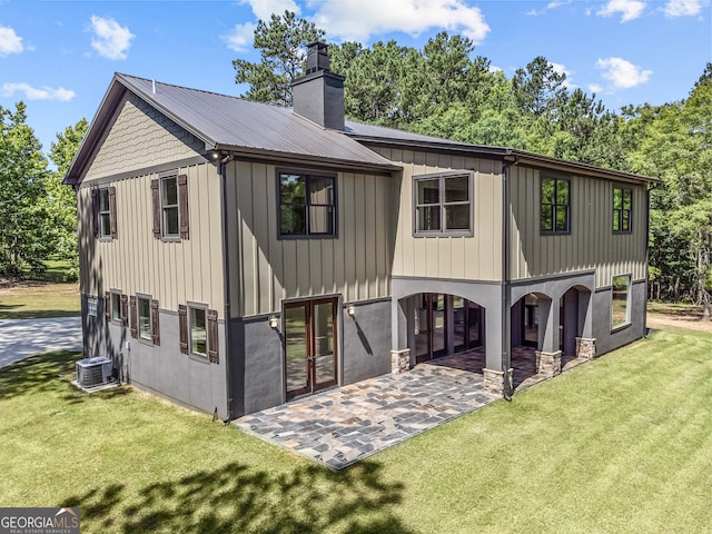 back of property with french doors, a lawn, a patio area, and cooling unit