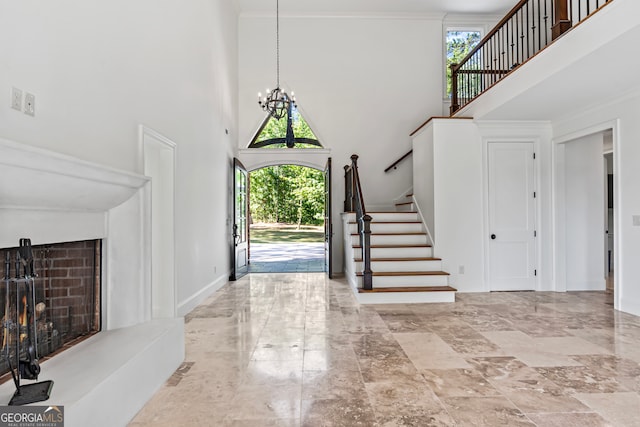 entryway featuring a towering ceiling and a notable chandelier