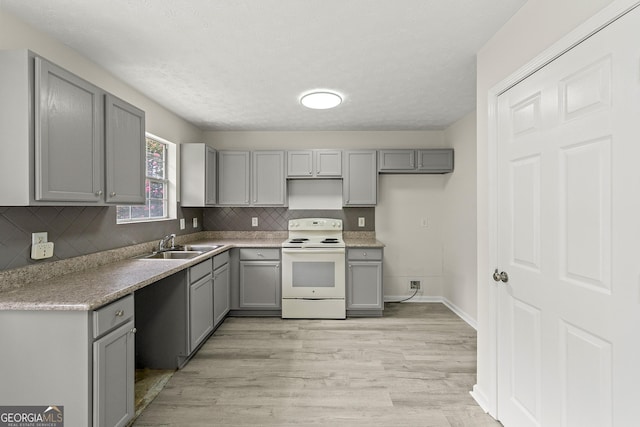 kitchen with gray cabinets, sink, electric range, and backsplash