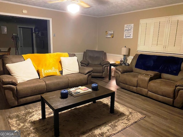 living room with hardwood / wood-style flooring, ornamental molding, ceiling fan, and a textured ceiling