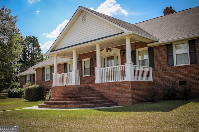 view of front facade with covered porch, a front yard, and ceiling fan