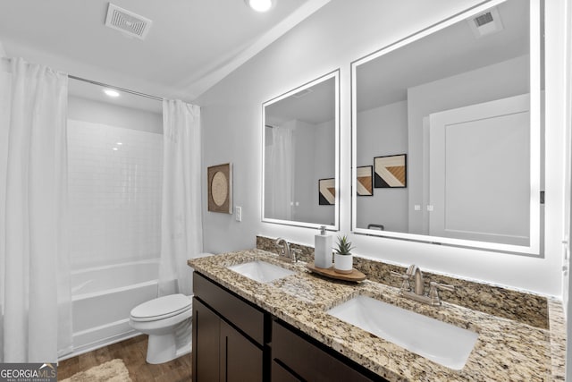 full bathroom with wood-type flooring, vanity, shower / tub combo, and toilet