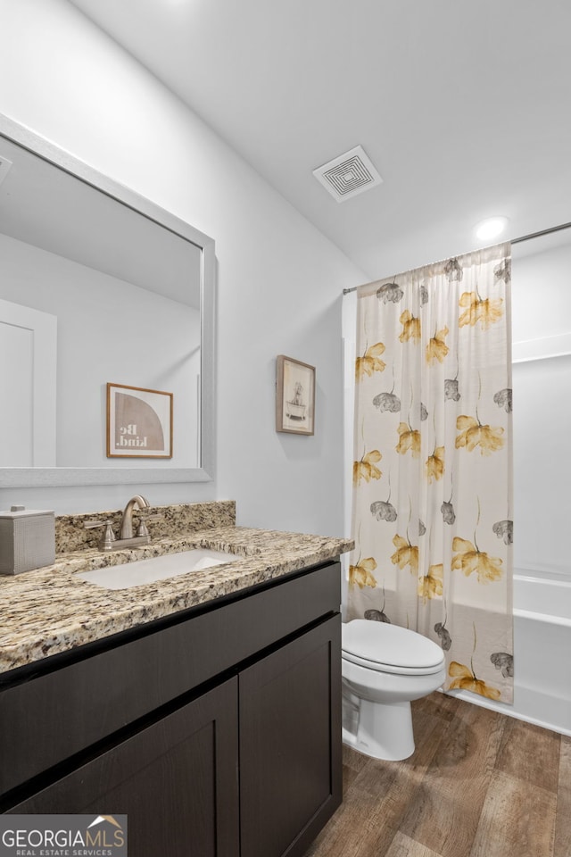 full bathroom featuring toilet, shower / bath combo with shower curtain, vanity, and hardwood / wood-style flooring