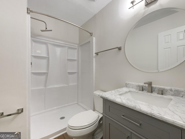 bathroom with vanity, toilet, and walk in shower