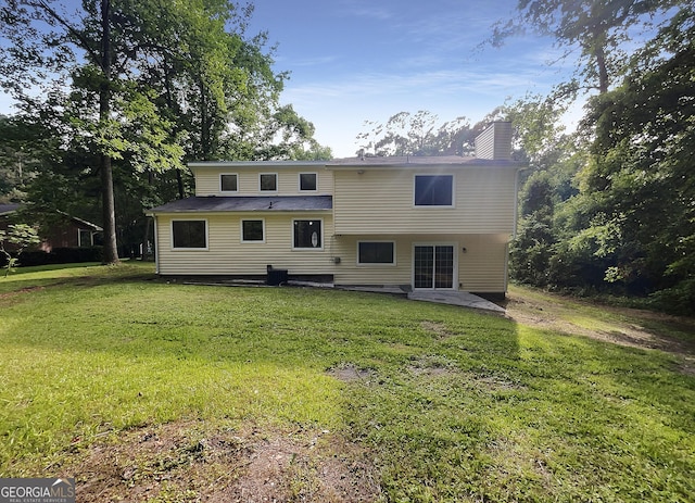 rear view of house featuring a yard and a patio