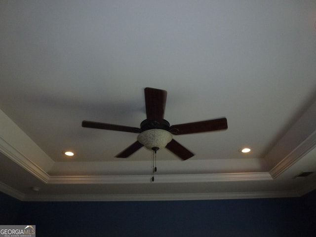 interior details with ornamental molding, ceiling fan, and a tray ceiling