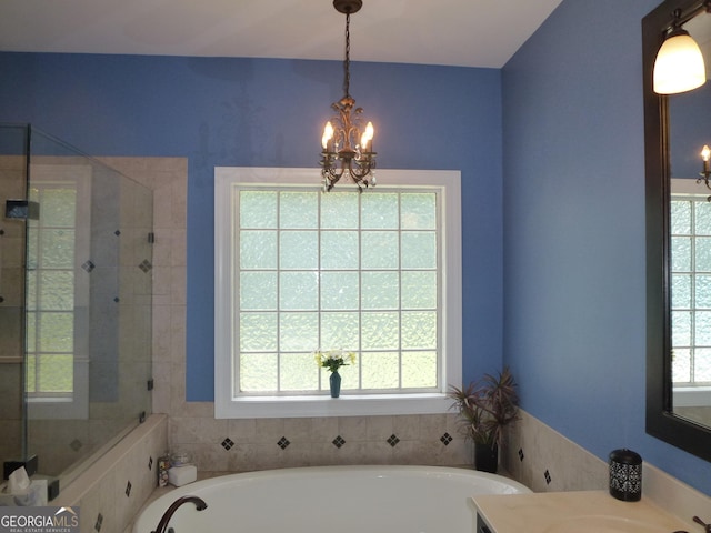 bathroom with an inviting chandelier, plenty of natural light, and plus walk in shower