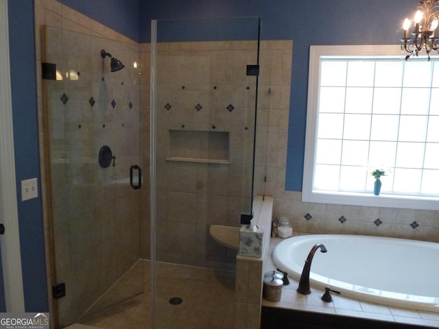 bathroom featuring an inviting chandelier, shower with separate bathtub, and plenty of natural light