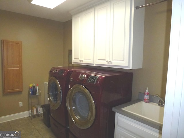 clothes washing area featuring sink, cabinets, tile patterned flooring, and washer and clothes dryer