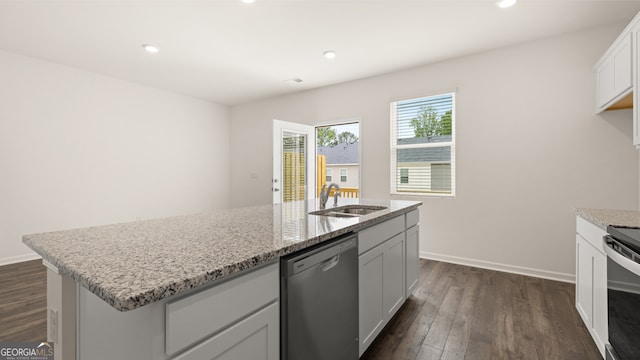 kitchen with dark hardwood / wood-style flooring, appliances with stainless steel finishes, a kitchen island with sink, sink, and white cabinetry