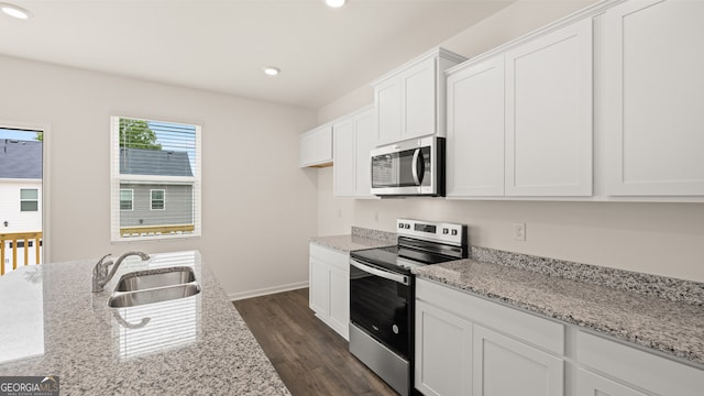 kitchen with stainless steel appliances, dark hardwood / wood-style flooring, sink, light stone countertops, and white cabinets