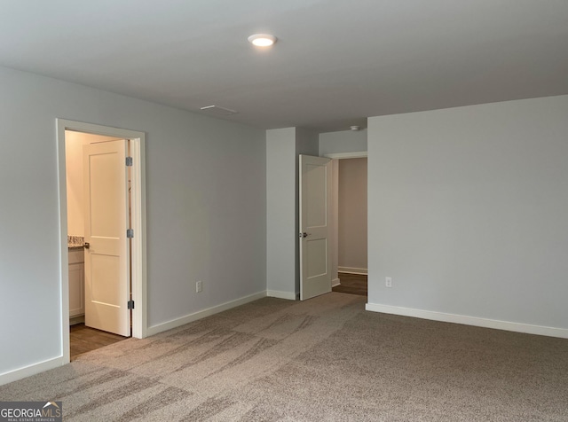 unfurnished bedroom with connected bathroom and carpet floors