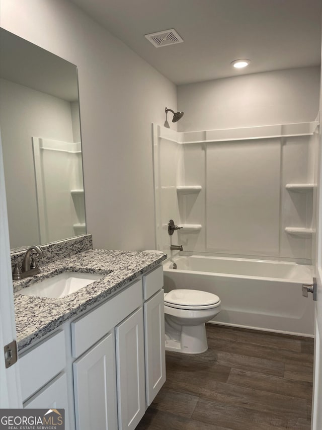 full bathroom with toilet, vanity, wood-type flooring, and tub / shower combination