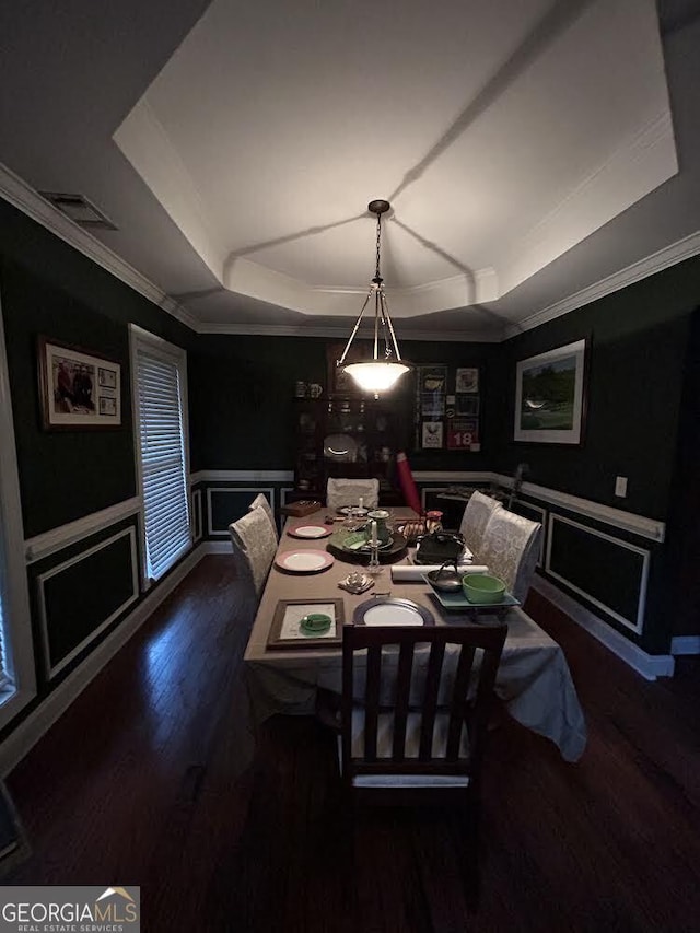 dining room with a tray ceiling, a wainscoted wall, a decorative wall, and visible vents