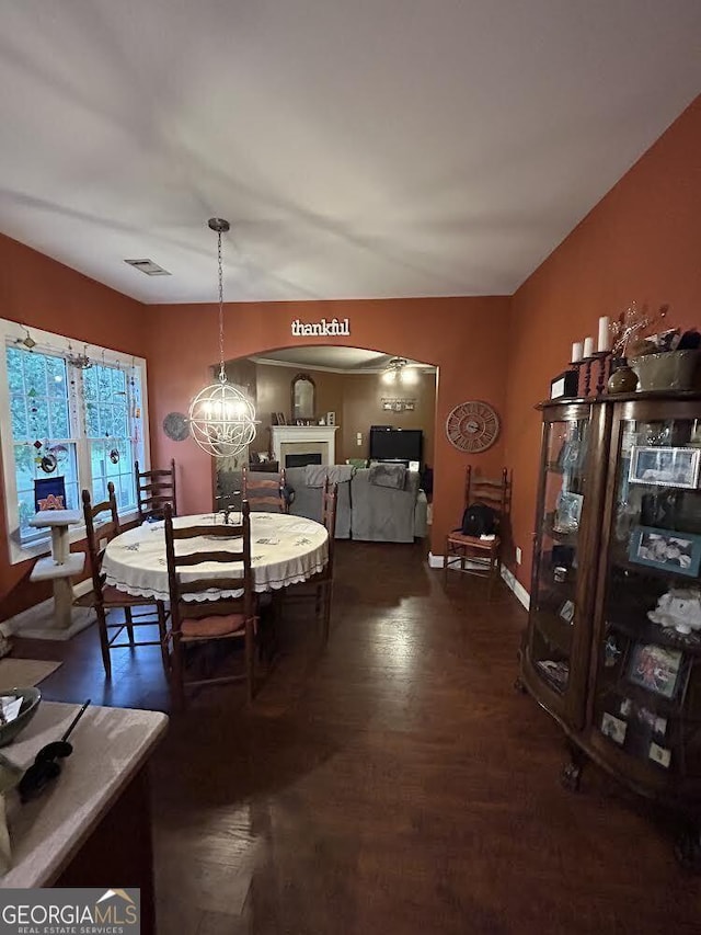 dining room with dark wood-style floors, a fireplace, visible vents, and baseboards