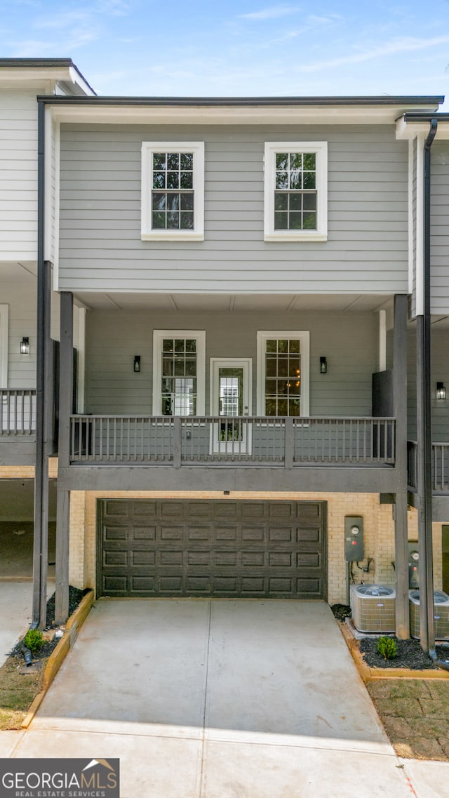 view of property featuring a balcony, a garage, and central AC