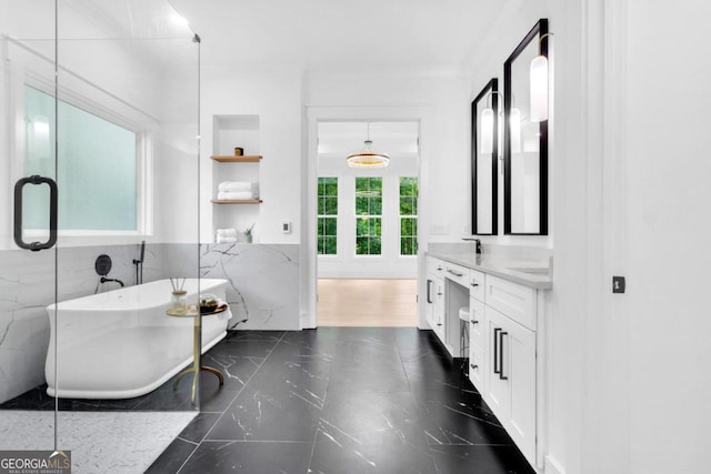 bathroom featuring vanity, a tub, and tile walls