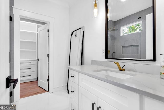 bathroom featuring hardwood / wood-style floors, vanity, and a shower with shower door