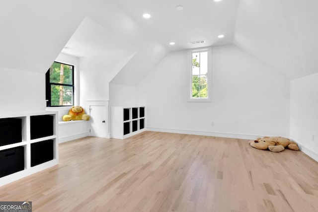 additional living space featuring light hardwood / wood-style floors and vaulted ceiling