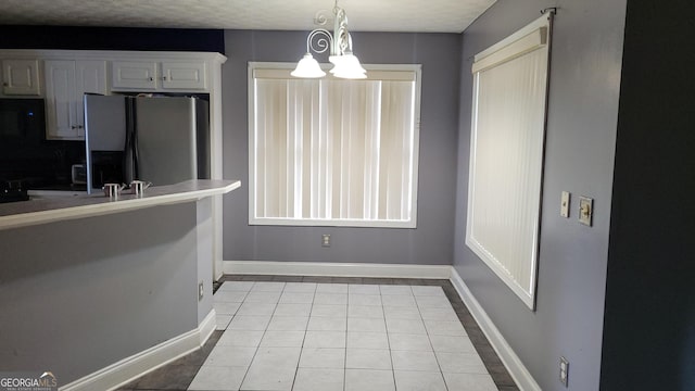 kitchen featuring white cabinetry, stainless steel fridge with ice dispenser, an inviting chandelier, decorative light fixtures, and light tile floors