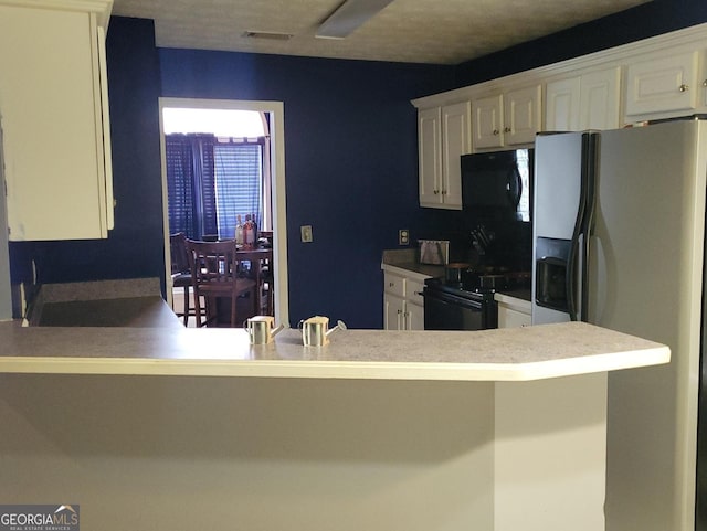 kitchen with stainless steel fridge with ice dispenser, white cabinets, and stove