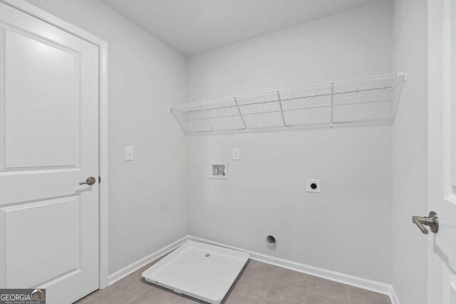 washroom with hookup for a washing machine, hookup for an electric dryer, and tile patterned flooring