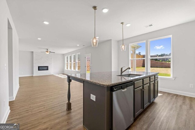 kitchen featuring dishwasher, dark wood-type flooring, stone counters, pendant lighting, and sink